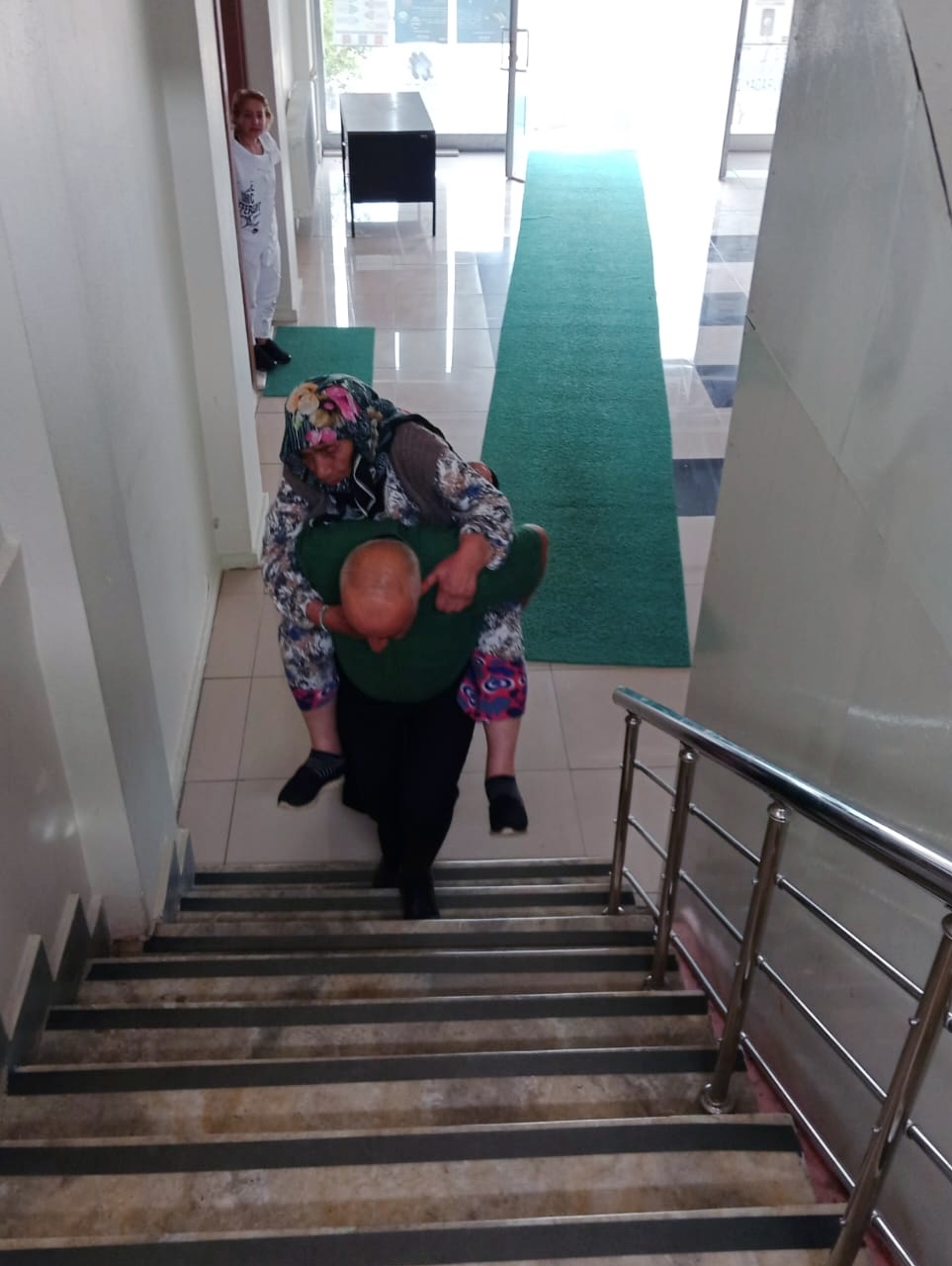 Nüfus müdürlüğü memuru, yaşlı kadını 1. kattaki müdürlük ofisine sırtında taşıdı